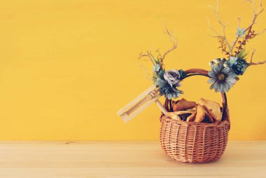 Purim kutlama kavramı (Yahudi karnaval tatil) geleneksel hamantasch kurabiye ve geyik boynuzları çiçek dekorasyonu ile ahşap masa üzerinde