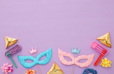 Purim kutlama kavram (Yahudi karnaval tatil) ahşap pembe bir arka plan üzerinde.