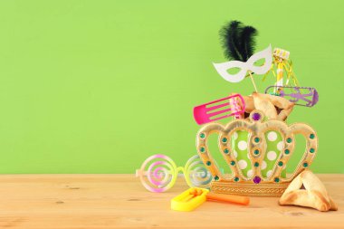 Ahşap masa ve mor arka plan üzerine Purim kutlaması konsepti (Yahudi karnavalı tatili)