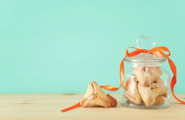 Purim kutlama kavramı (Yahudi karnaval tatil). Geleneksel hamantaschen Çerezler üzerinde ahşap masa