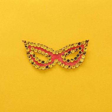 Karnaval parti kutlama kavramı ile kağıt maskeyi sarı arka plan üzerine. Üstten Görünüm. Düz yatıyordu