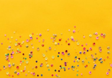 Sarı bir kağıt üzerine pastel renkli pul. Dikiş ve parti dekoratif aksesuarlar. Metin için yer ile boş arka plan