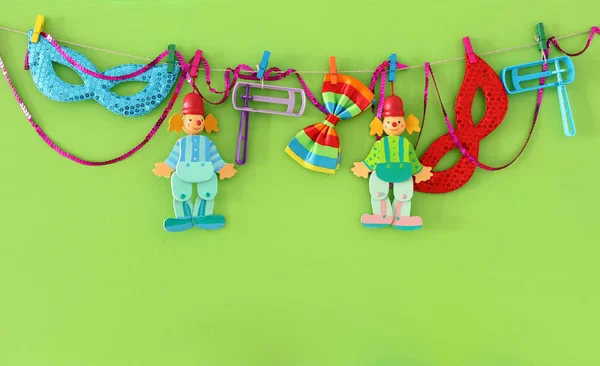 Purim ünnepe koncepció (zsidó farsangi ünnep), bohócok, maszkok és eredményezhetett felett fa zöld háttér — Stock Fotó
