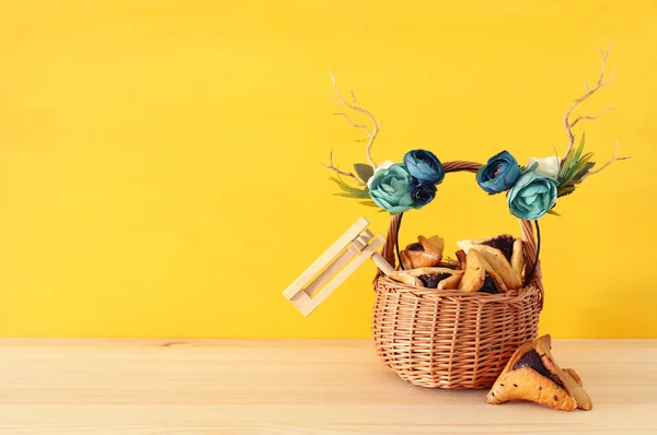 木製テーブルの上 hamantasch の伝統的なクッキーや鹿アントラーズ花飾り付きプリムのお祝い概念 (ユダヤ人のカーニバルの休日) — ストック写真