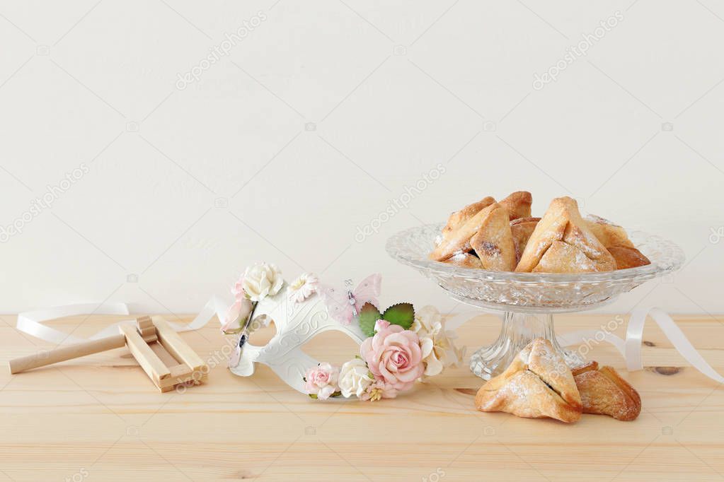 Purim celebration concept (jewish carnival holiday) over wooden table.