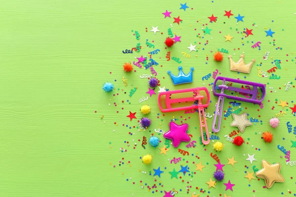 Conceito de celebração Purim (feriado de carnaval judaico) confete e barulhento sobre fundo verde de madeira — Fotografia de Stock