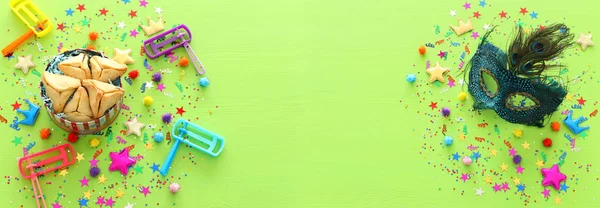 Concepto de celebración Purim (fiesta de carnaval judío) sobre fondo verde madera. vista superior, cama plana. banner —  Fotos de Stock