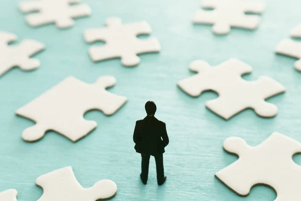 Puzzlesteine mit Miniaturmenschen über Holztisch, Personalwesen, Problemlösung und Managementkonzept — Stockfoto