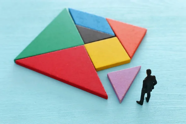 Tangram puzzle blokkok miniatűr emberek több mint a fából készült asztal, emberi erőforrások, a probléma megoldása és a menedzsment fogalma — Stock Fotó