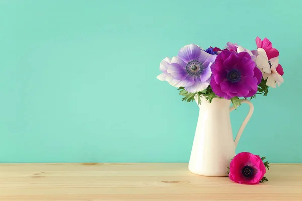 Frühlingsstrauß bunter Anemonen in der Vase über Holztisch — Stockfoto