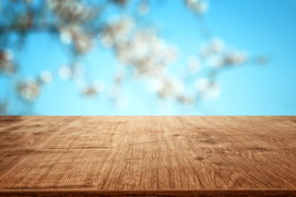 Drewniany stolik przed wiosennym krajobrazem drzewa. Wyświetlanie i prezentacja produktu — Zdjęcie stockowe
