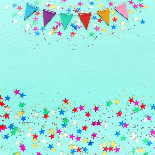 Party colorful confetti over light pastel blue wooden background . Top view, flat lay — Stock Photo, Image