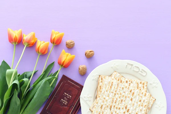 Concetto di celebrazione di Pesah (festa ebraica di Pasqua). Libro tradizionale con testo in ebraico: Pesach Haggadah (Racconto di Pasqua) e piatto con la parola PASSOVER — Foto Stock