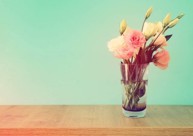 ahşap masa ve pastel nane arka plan üzerinde Vazoda beyaz ve pembe çiçekler buket yaz