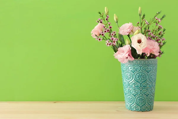 Ramo de primavera de pastel y delicadas flores de color rosa en el jarrón sobre la mesa de madera —  Fotos de Stock