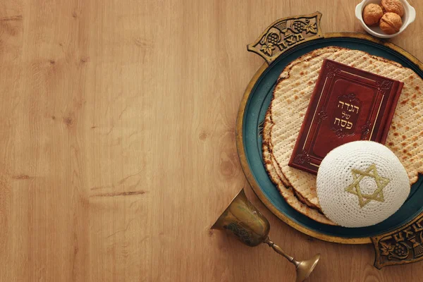 Pesah celebration concept (jewish Passover holiday). Translation for Hebrew Text over plate (Matzah) Matza and Traditional book with text in hebrew: Passover Haggadah (Passover Tale) — Stock Photo, Image