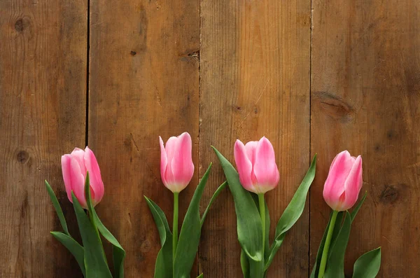 Bouquet of pink tulips over wooden background. Top view — Stock Photo, Image