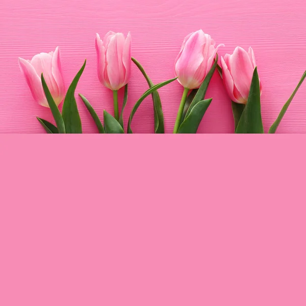 Bouquet tulips over pastel pink wooden background. Top view — Stock Photo, Image