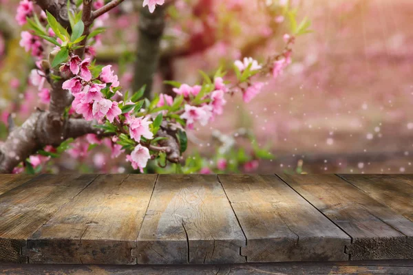 Mesa de madeira na frente da paisagem da árvore da flor da mola. Exibição e apresentação do produto — Fotografia de Stock