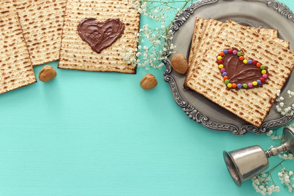 Pesah viering concept (Joodse Pascha vakantie) met chocolade hart en kleurrijke snoepjes over matzah. Bovenaanzicht plat leggen — Stockfoto