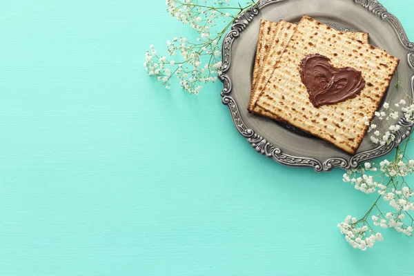 Pesah fest koncept (judisk påsk semester) med choklad hjärta över matzah. Ovanifrån platt låg — Stockfoto