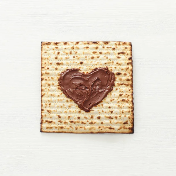 Pesah kutlama kavramı (Yahudi Fısıh Bayramı) matzah üzerinde çikolata kalp ile. Üstten Görünüm düz yatıyordu — Stok fotoğraf