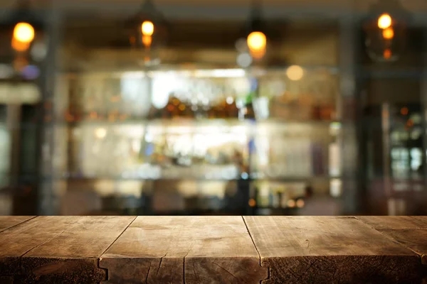 Imagen de mesa de madera frente a abstracto borroso restaurante luces fondo — Foto de Stock