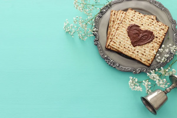 Concepto de celebración de Pesah (fiesta judía de Pascua) con corazón de chocolate sobre matzah. Vista superior plano laico — Foto de Stock
