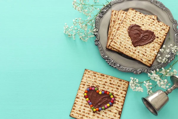 Concepto de celebración de Pesah (fiesta judía de Pascua) con corazón de chocolate y dulces de colores sobre matzah. Vista superior plano laico — Foto de Stock