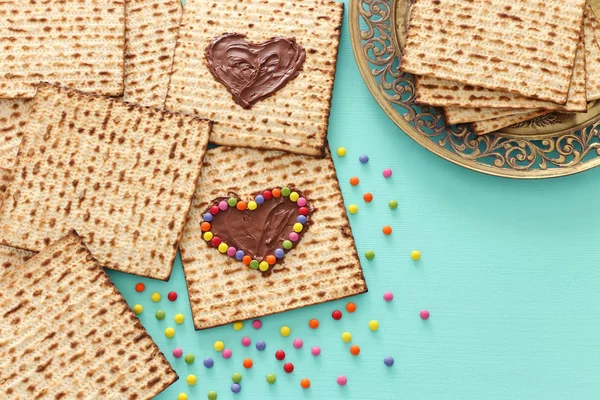 Pesah viering concept (Joodse Pascha vakantie) met chocolade hart en kleurrijke snoepjes over matzah. Bovenaanzicht plat leggen — Stockfoto