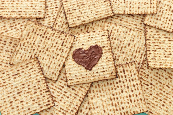 Pesah viering concept (Joodse Pascha vakantie) met chocolade hart over matzah. Bovenaanzicht plat leggen — Stockfoto