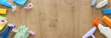 Bahar temizliği malzemeleri konseptiyle ahşap arka plan üzerinde. Üstten Görünüm, düz yatıyordu