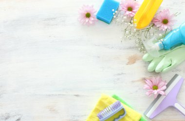 Bahar temizliği malzemeleri konseptiyle Beyaz ahşap arka plan üzerinde. Üstten Görünüm, düz yatıyordu