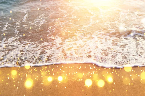 Imagen de fondo de la playa de arena y las olas del océano con luces bokeh brillantes — Foto de Stock