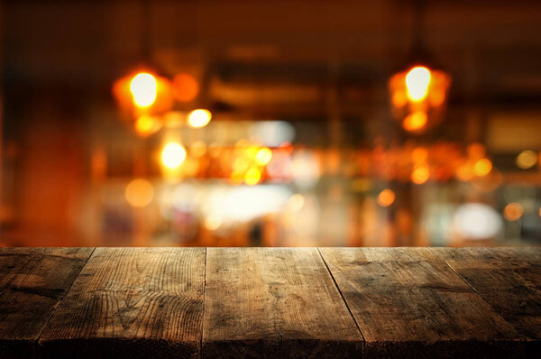 Изображение деревянного стола перед абстрактным размытым фоном ресторана

