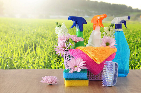 Spring cleaning concept with supplies on wooden table