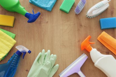 Bahar temizliği malzemeleri konseptiyle ahşap arka plan üzerinde. Üstten Görünüm, düz yatıyordu