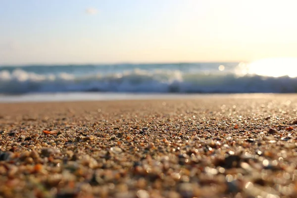 Pozadí obrázek písečné pláže a oceánské vlny s jasnými bokeh světla — Stock fotografie