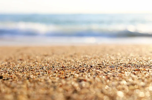 明るいボケの光を持つ砂浜と海の波の背景画像 — ストック写真
