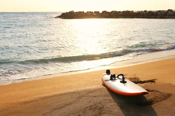 Серфинг на песчаном пляже во время захода солнца — стоковое фото
