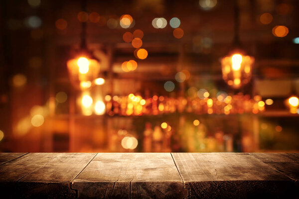 Изображение деревянного стола перед абстрактным размытым фоном ресторана
