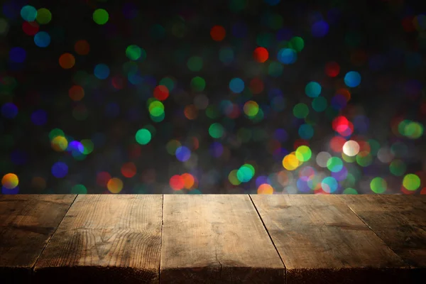 Trä bord framför glitter svart och guld bokeh lampor. För produkt presentation — Stockfoto