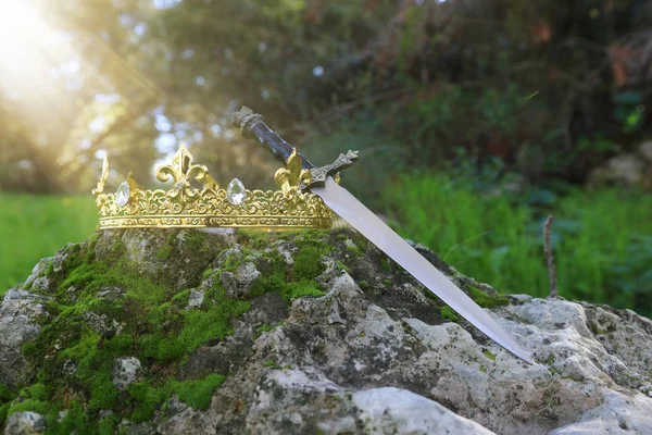 Misteriosa e mágica foto do rei do ouro coroa e espada no — Fotografia de Stock