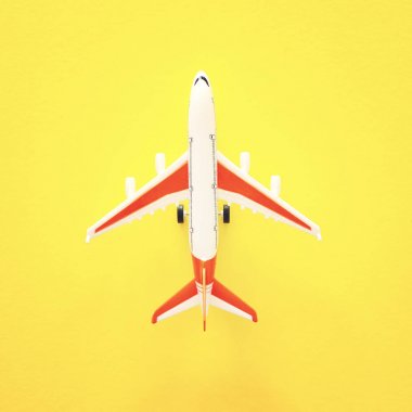 sarı arka plan üzerinde oyuncak uçak üst görünüm fotoğrafı