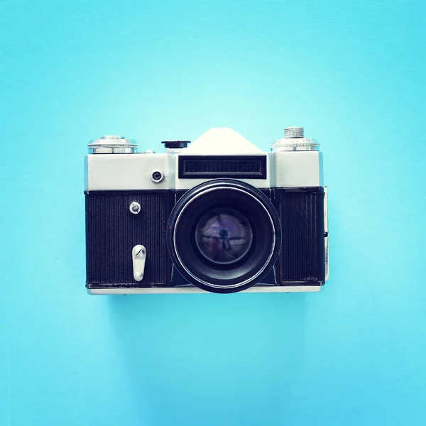 Pohled na starou fotografickou kameru přes modré pozadí — Stock fotografie
