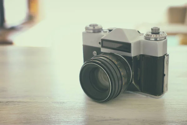 Vieja cámara de fotos sobre escritorio de madera blanca. Vintage filtrado —  Fotos de Stock