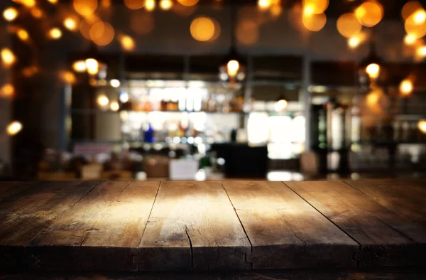 Mago de mesa de madera en frente de abstracto borroso restaurante luces fondo — Foto de Stock