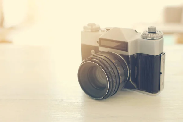 Gammal foto kamera över vitt trä skrivbord. Vintage filtrerad — Stockfoto