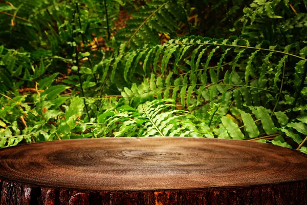 Table en bois devant un fond floral vert tropical. pour l'affichage et la présentation des produits — Photo