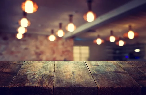 Εικόνας του ξύλινο τραπέζι μπροστά από αφηρημένη θολή εστιατόριο φώτα φόντο — Φωτογραφία Αρχείου